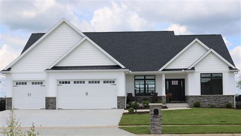 white ranch house with black metal roof|white brick house with black roof.